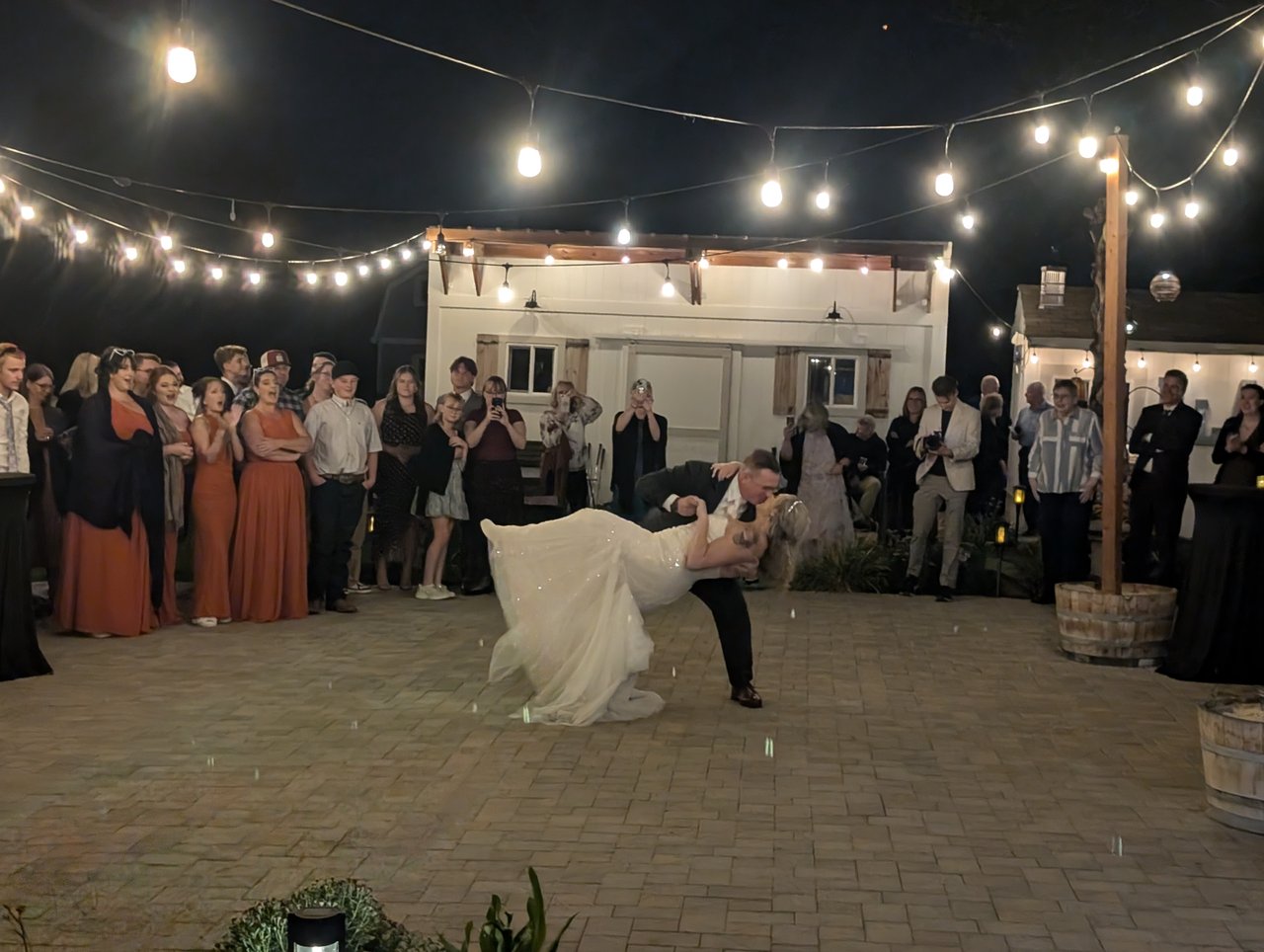 Logan dips Emily for a kiss during their first dance under the string lights