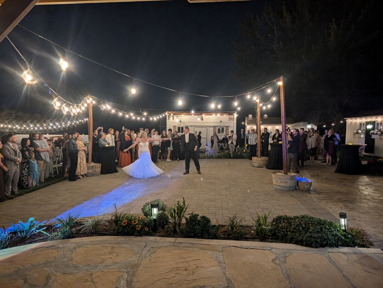 Emily turns in a pool of light during the first dance under the string lights