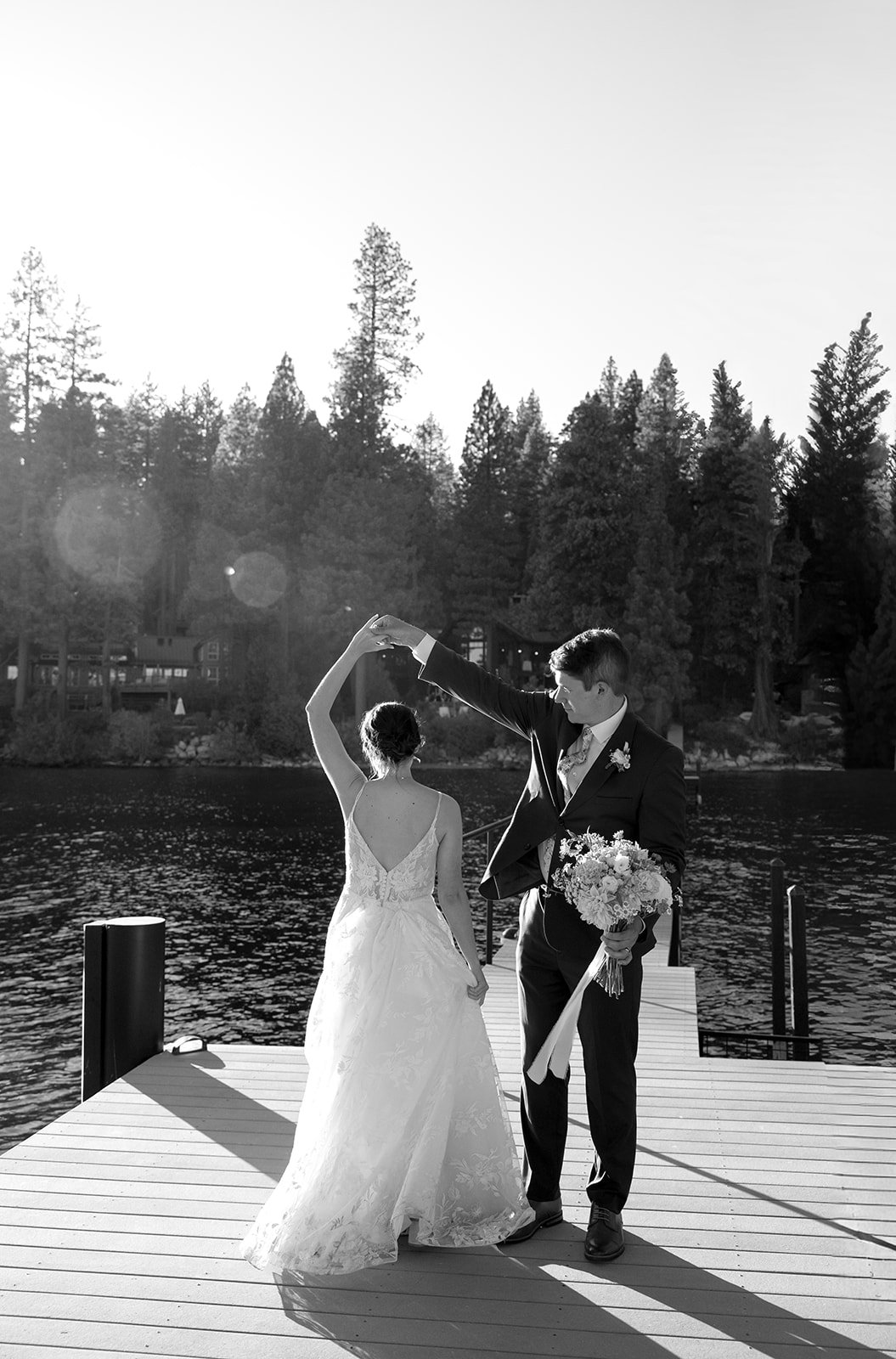 Jackson twirls Emma on the dock, her hand held high, in black and white