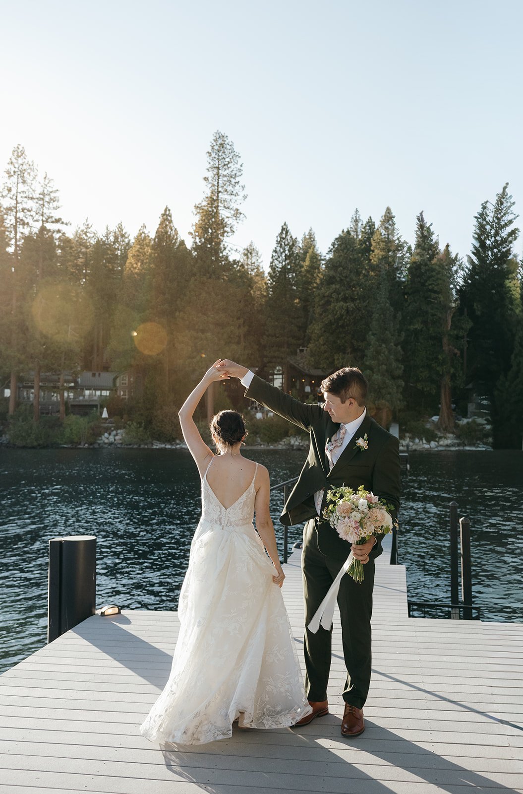 Jackson twirls Emma on the dock in the low sun, the lake and pines behind them