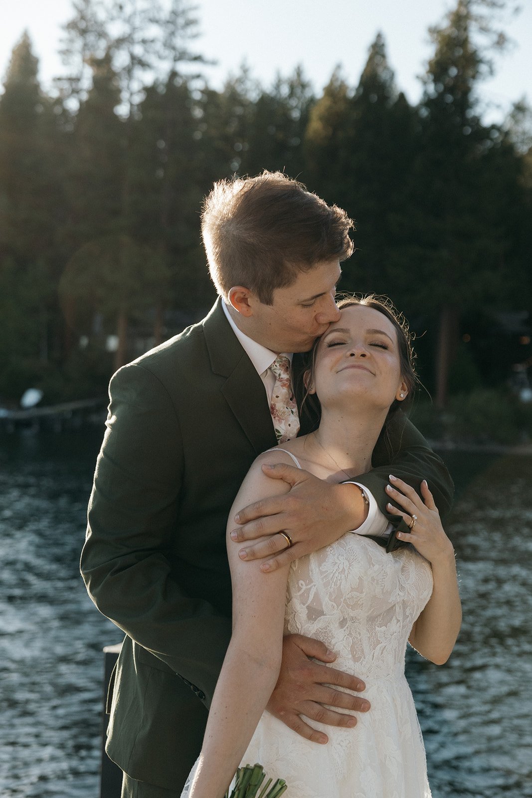 Jackson kisses the top of Emma's head as she smiles with her eyes closed