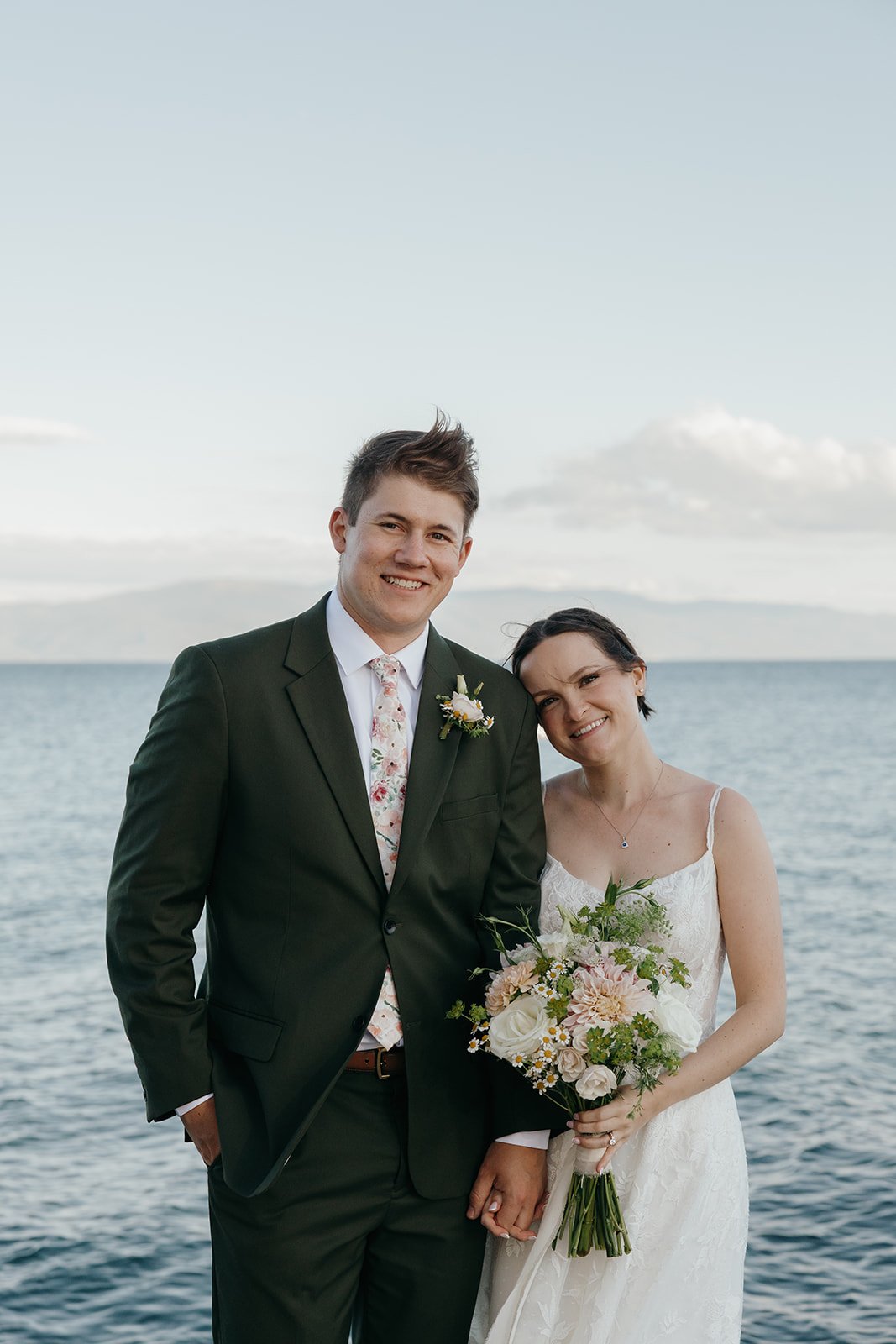 Jackson grins and Emma leans into him with Lake Tahoe and the far mountains behind