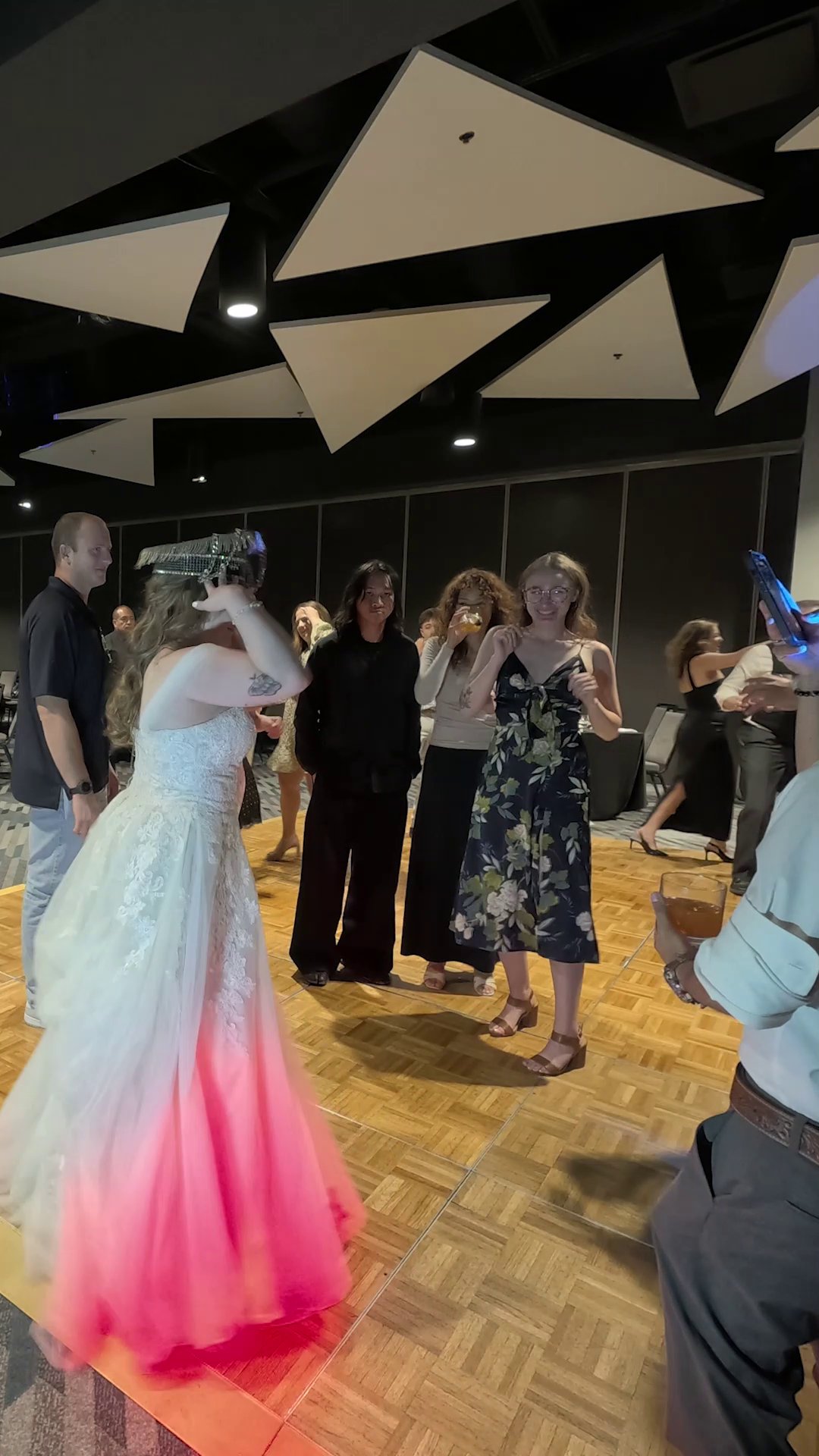 Hailey tries on a sparkly captain hat on the dance floor as the lights turn her gown pink