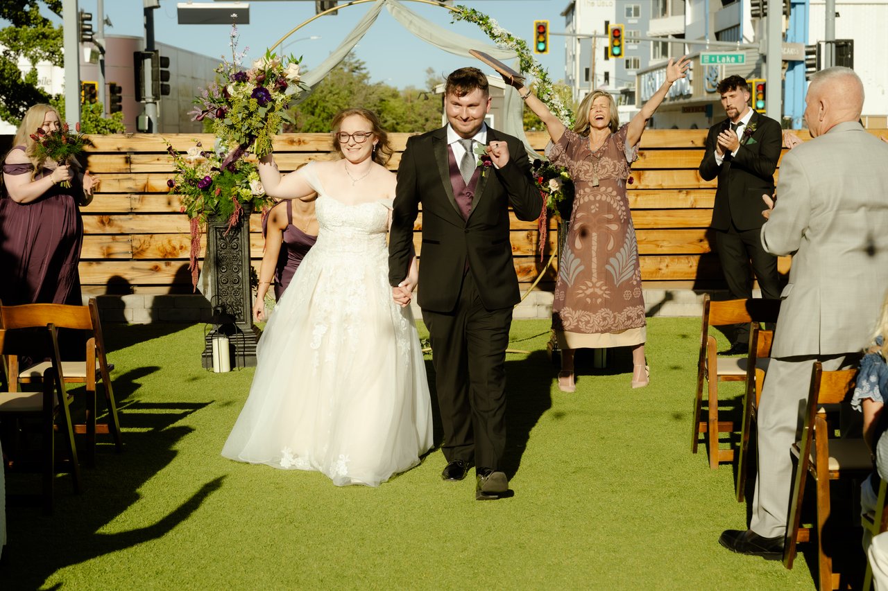 Hailey and Zen walk back up the aisle as everyone cheers