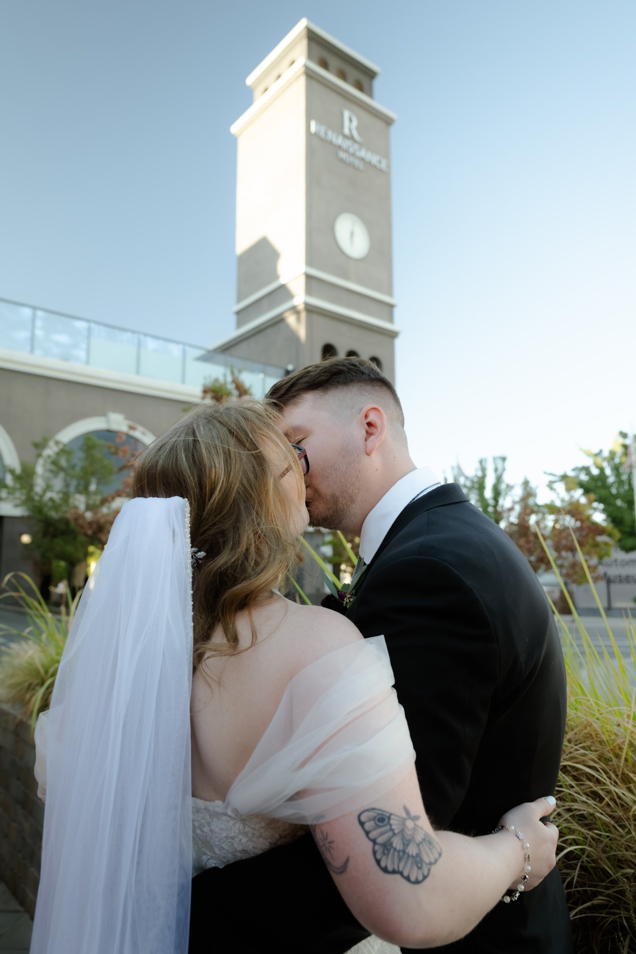Hailey and Zen kiss below the clock tower