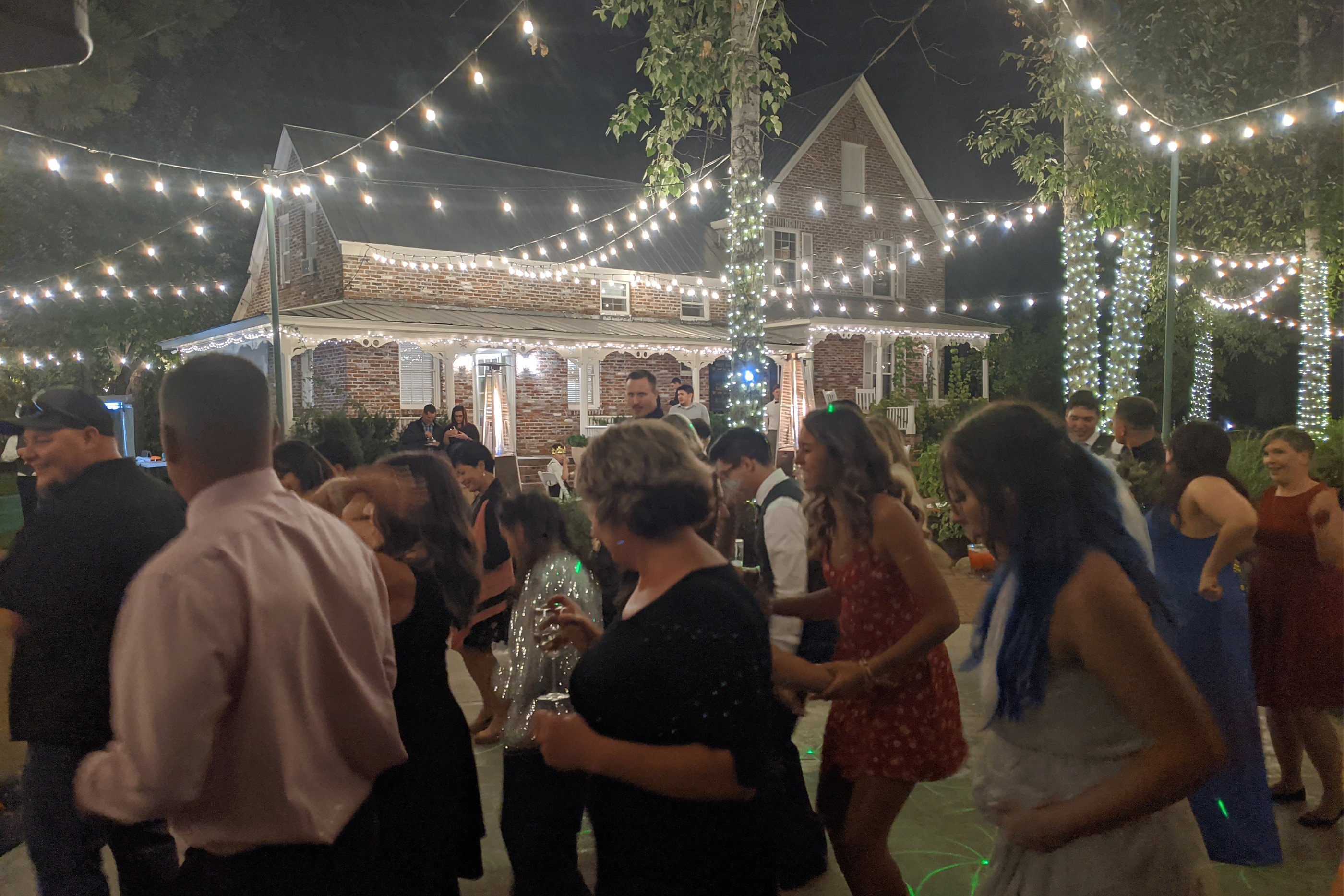 Hannah and Kyle kiss in the forest aisle between wine barrels and lanterns as their guests cheer, photo by Composing Reality Photography