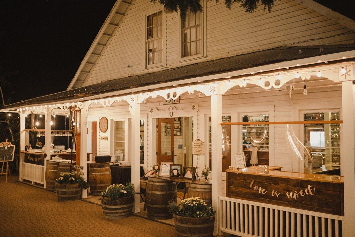 The General Store porch glowing at night with a love is sweet bar sign