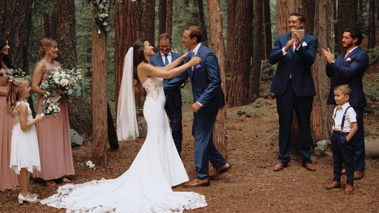 Jen throws her arms out at the end of the ceremony as the wedding party cheers
