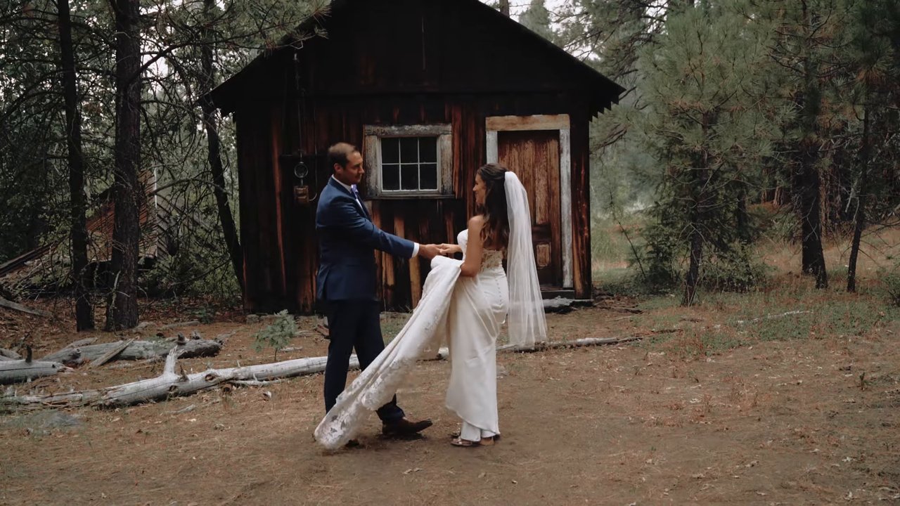 Wes holds Jen's train as they turn in front of the old cabin