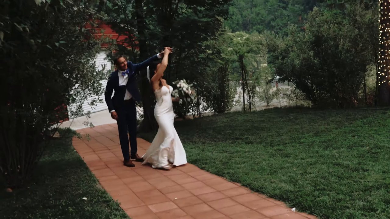 Wes twirls Jen on the brick garden path