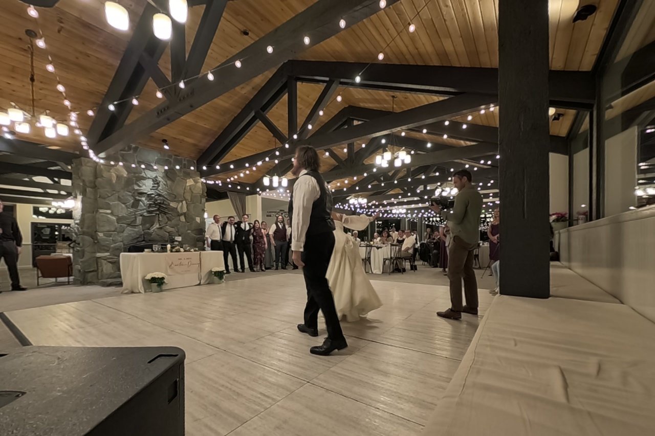 George and Jericha share their first dance under the string lights as their guests watch
