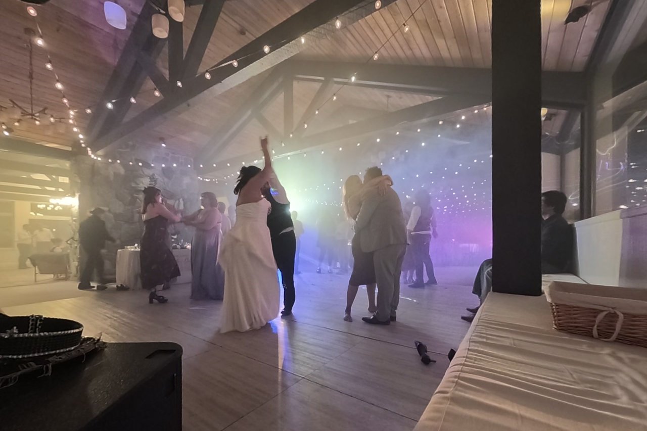 Jericha throws a hand in the air in the haze with her guests around her