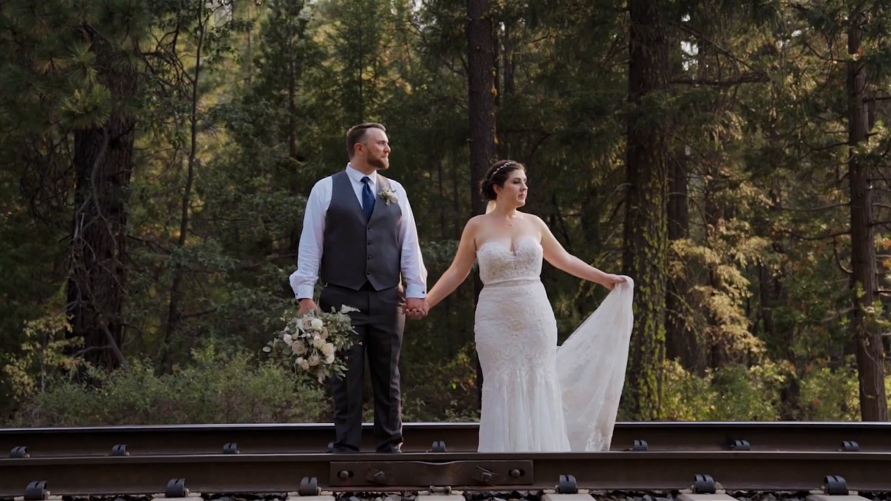 Jessie and Jeff stand together on the railroad tracks