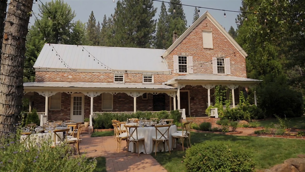 Guests at dinner tables in front of the brick house