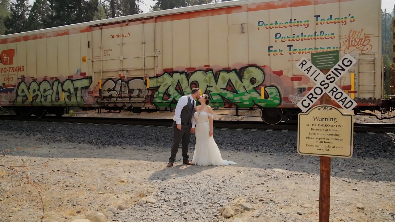 Jessie and Jeff kiss by the railroad crossing sign