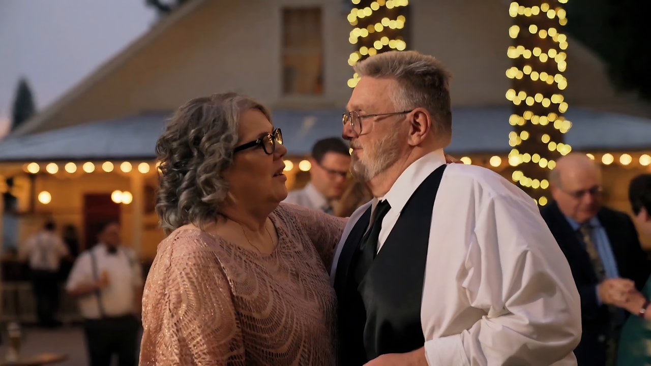 Parents dance together under the string lights