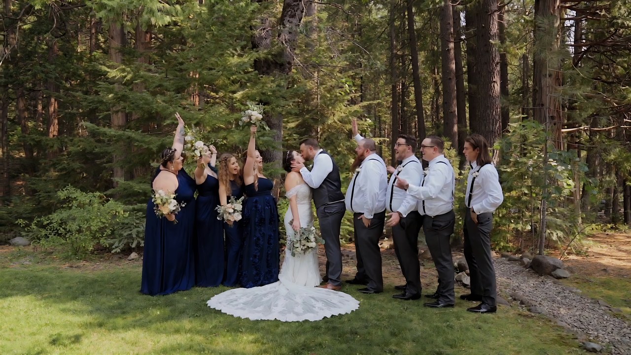 The wedding party cheers together in the forest