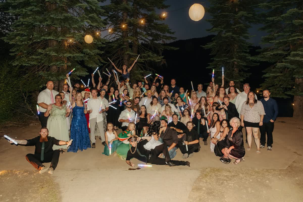 The whole wedding party under paper lanterns at night at Kaitlyn & Tristan's Bucks Lake wedding