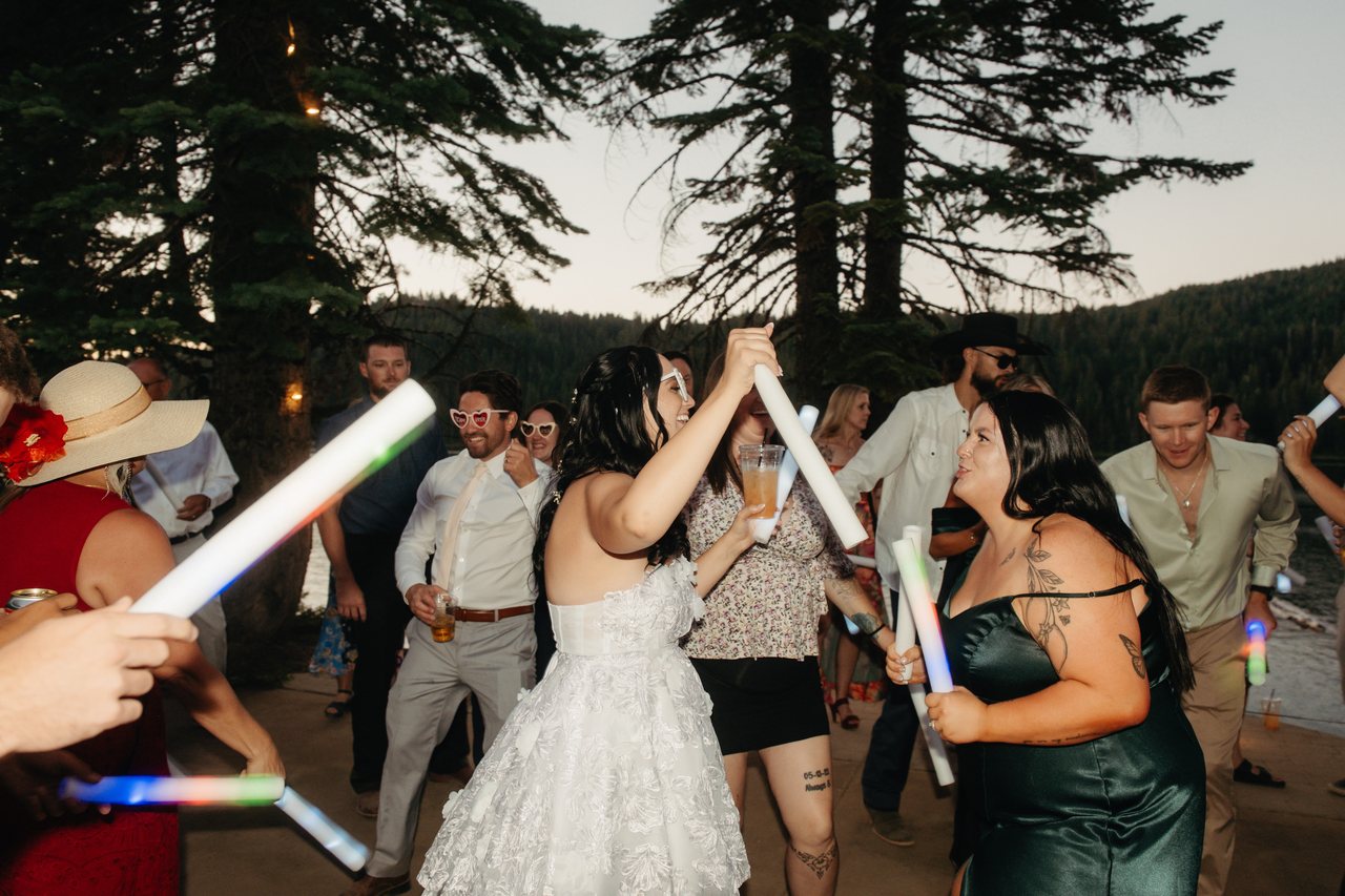Kaitlyn dances with her friends as glowing foam batons swing around them