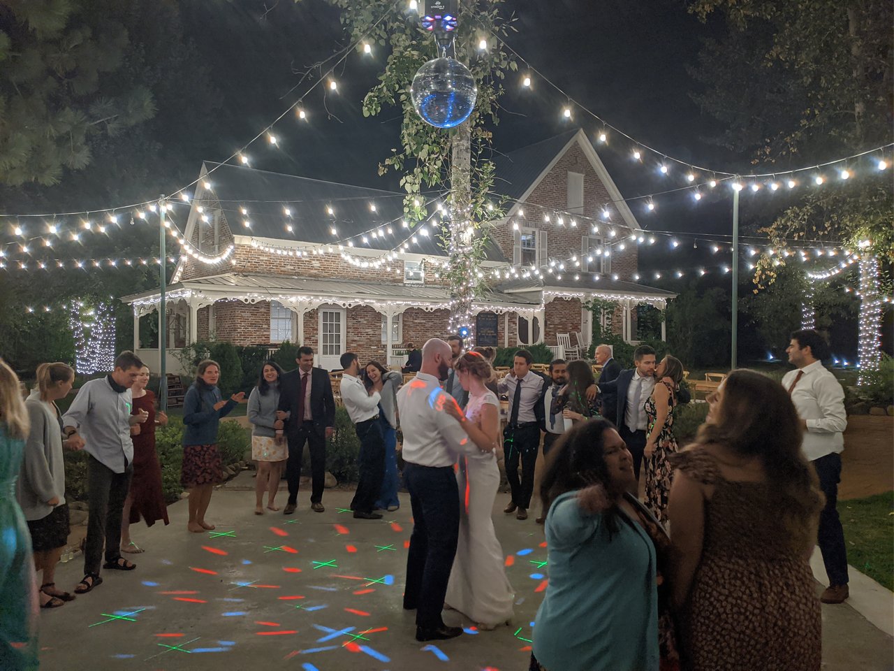 Lauren and Mark dance under colored lights on the dance floor
