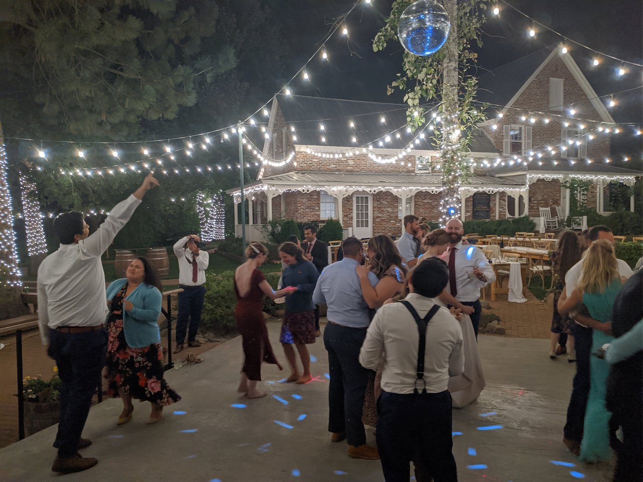 The disco ball lights up the dance floor under the string lights