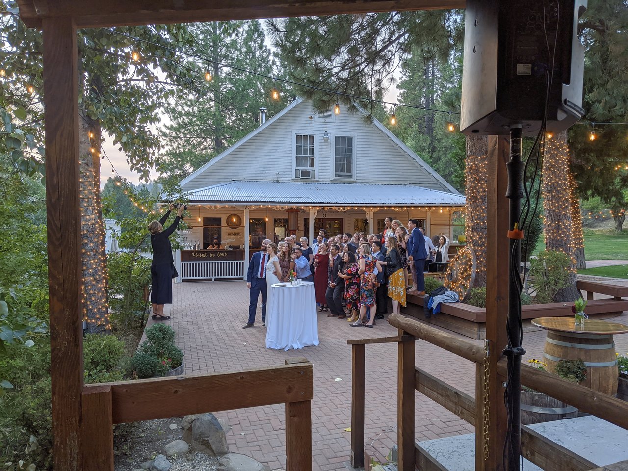 Guests gather in front of the white farmhouse for a group photo