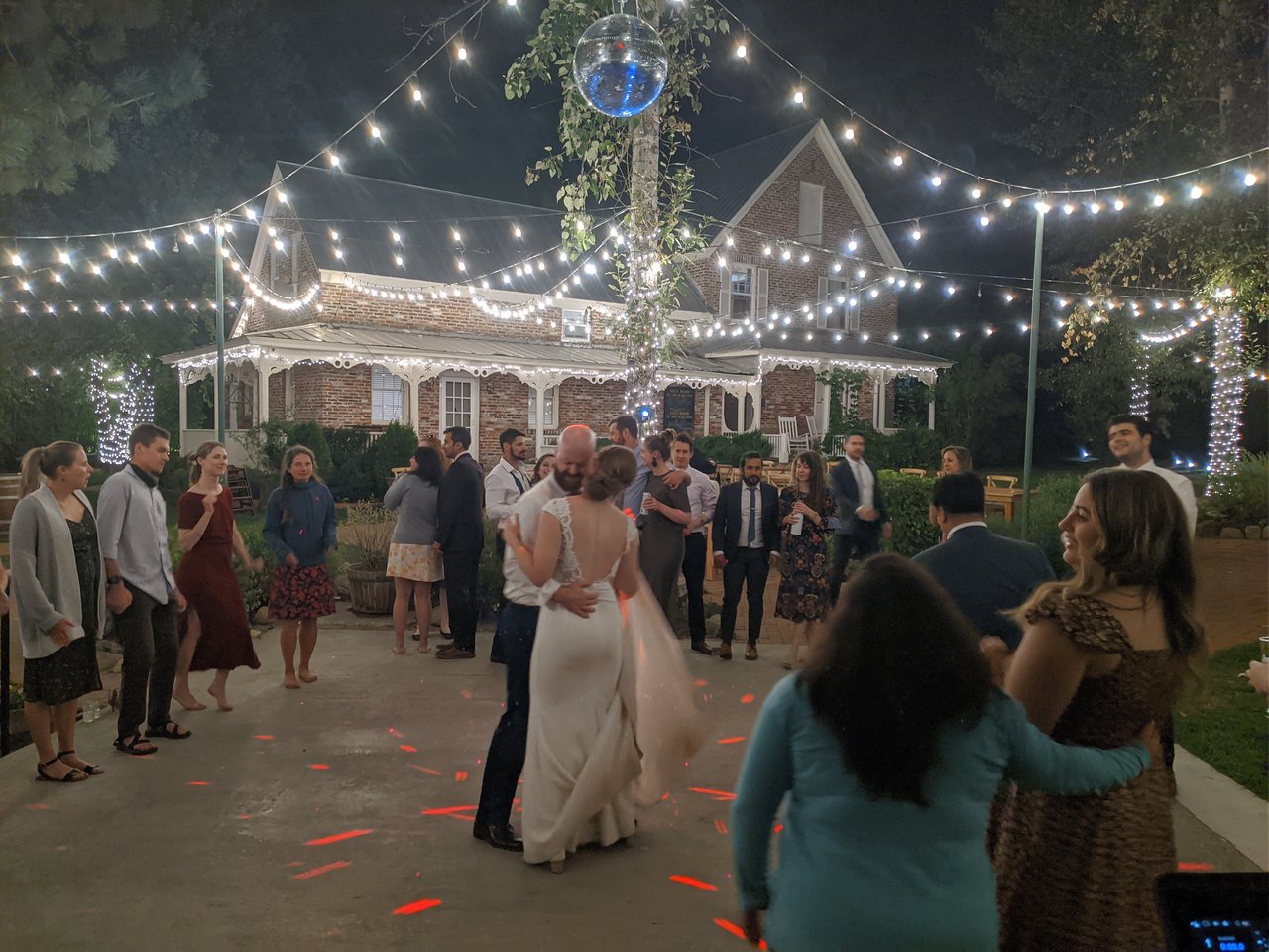 Lauren and Mark embrace during their last dance under string lights and a disco ball