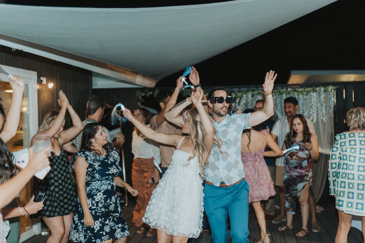 Guests with their arms up around Lexy and Jeremy