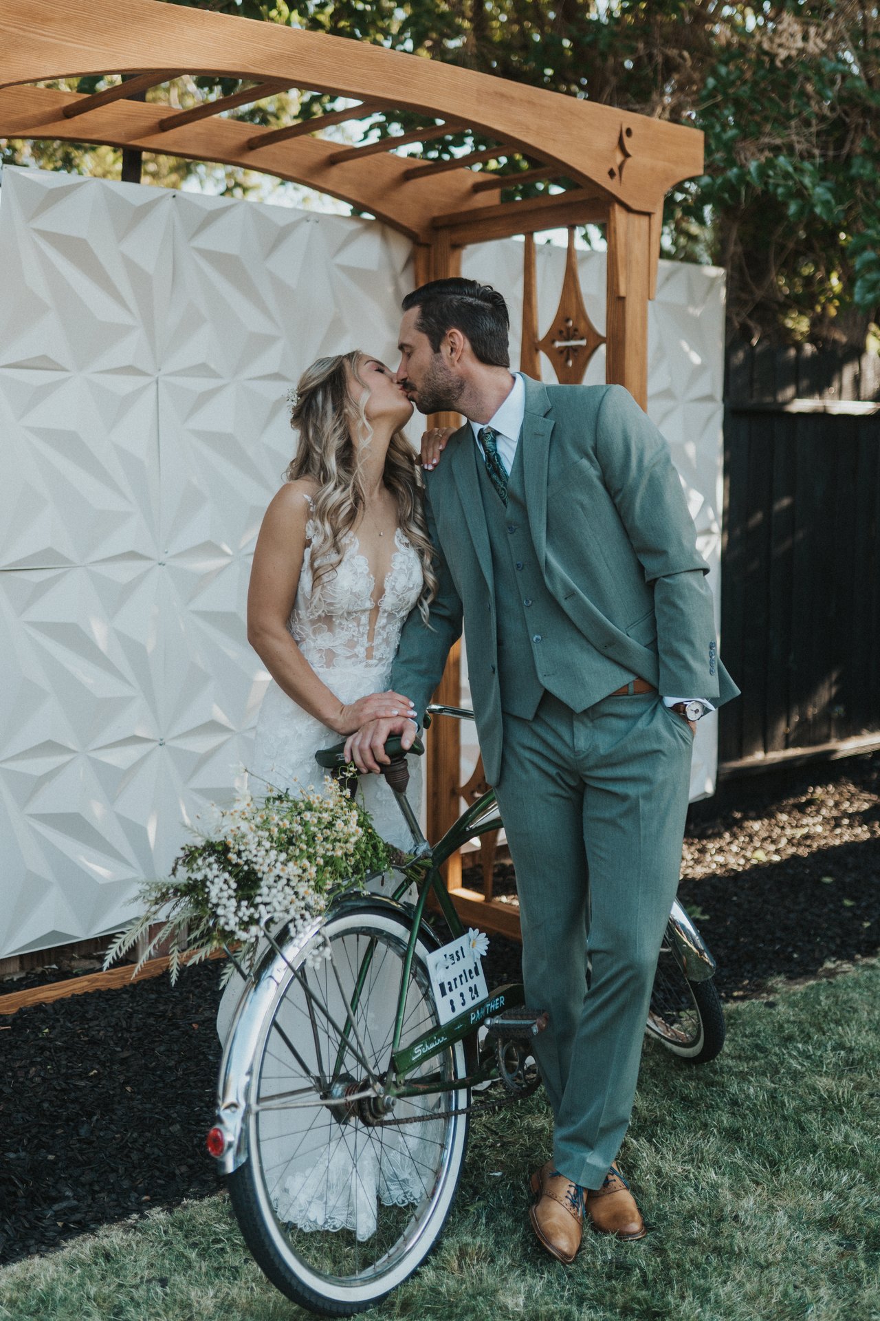 Lexy and Jeremy kiss beside the bike