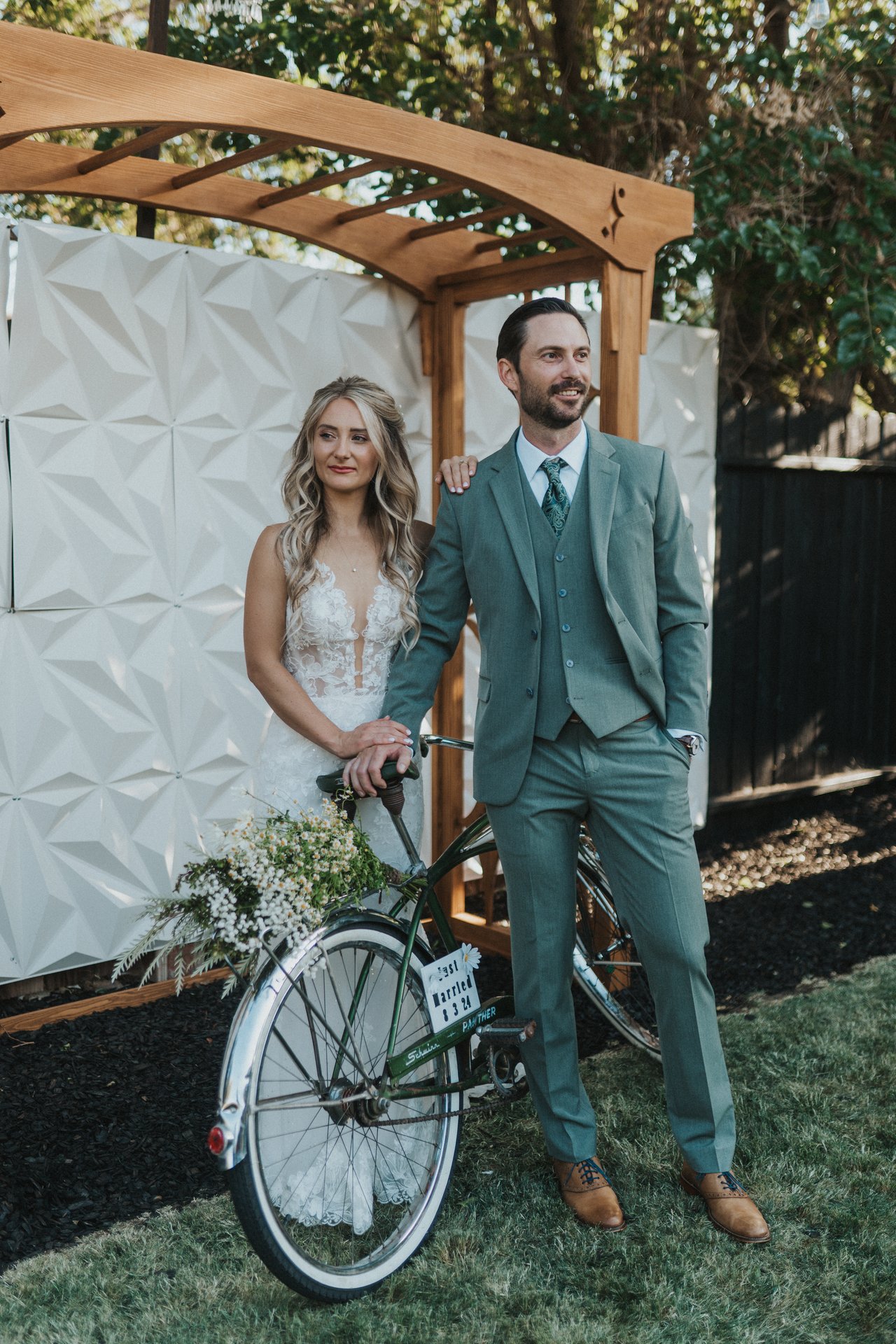 Lexy and Jeremy stand with the bike by the arbor