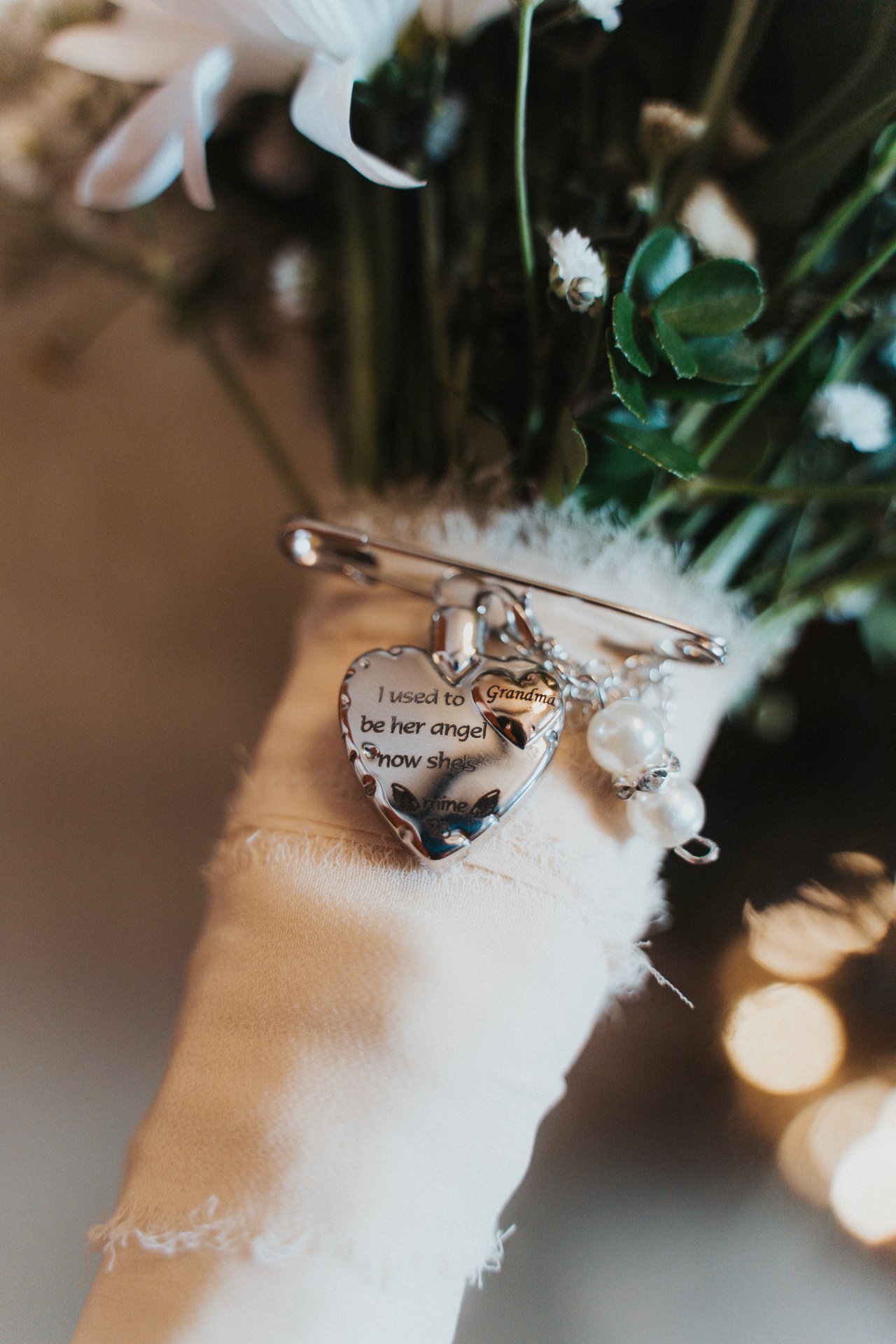 A photo charm pinned to the wrap of Lexy's bouquet