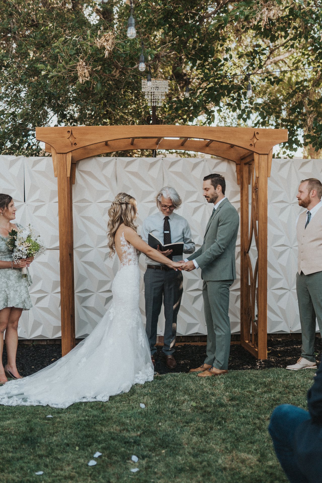 Lexy and Jeremy holding hands at the arbor