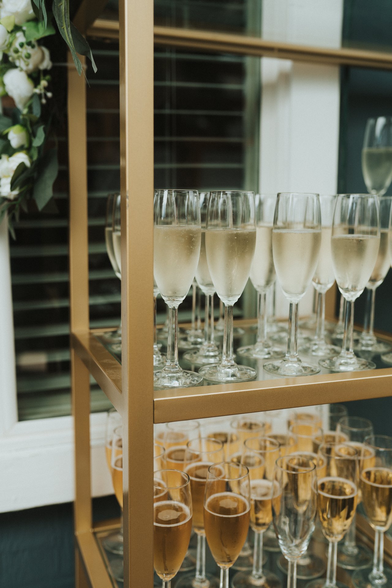 Glasses of champagne on a gold bar cart