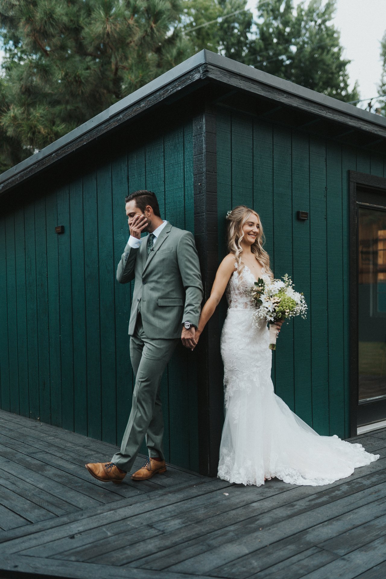 Lexy and Jeremy hold hands around the corner of the shed