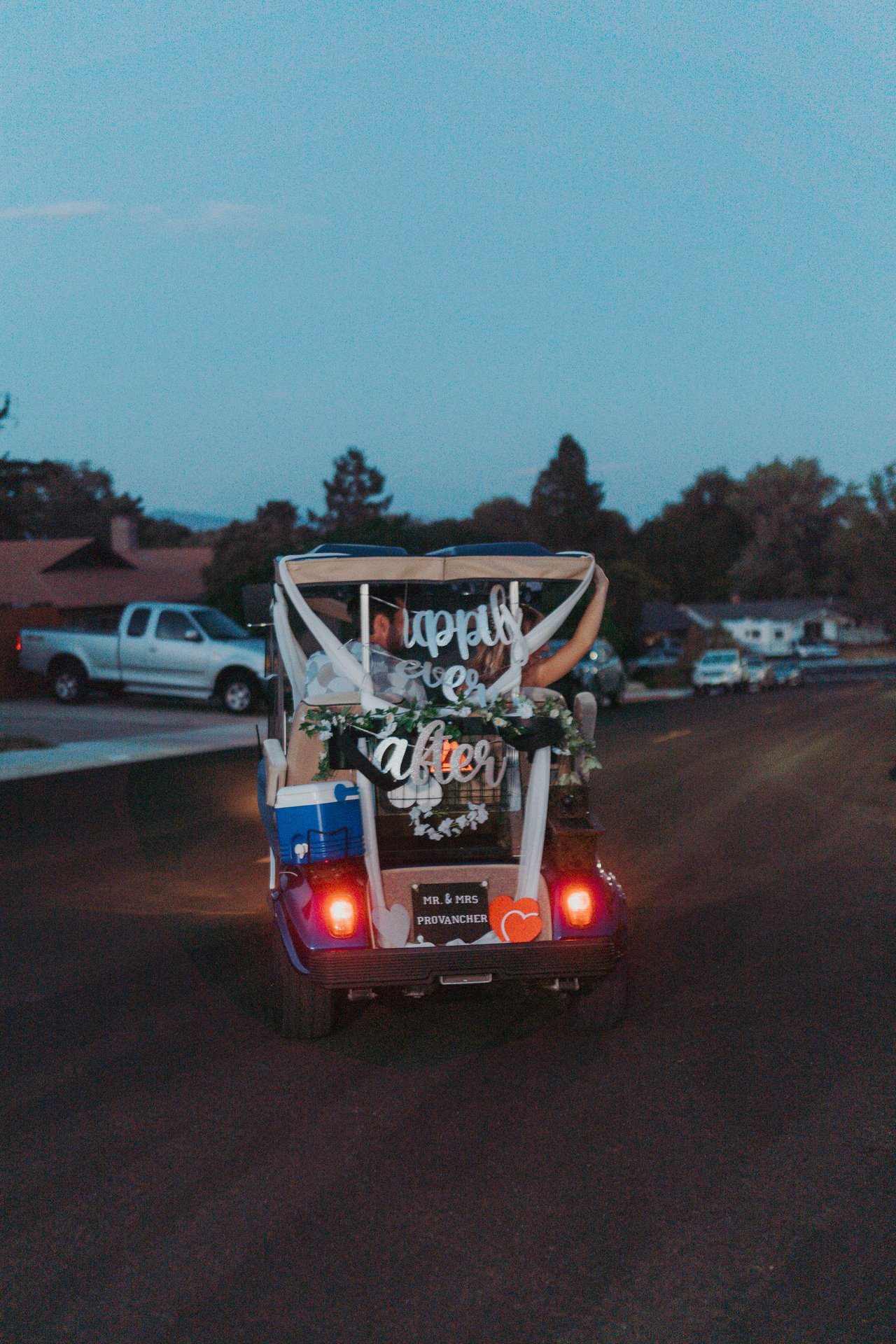 Lexy and Jeremy drive off in the golf cart at dusk