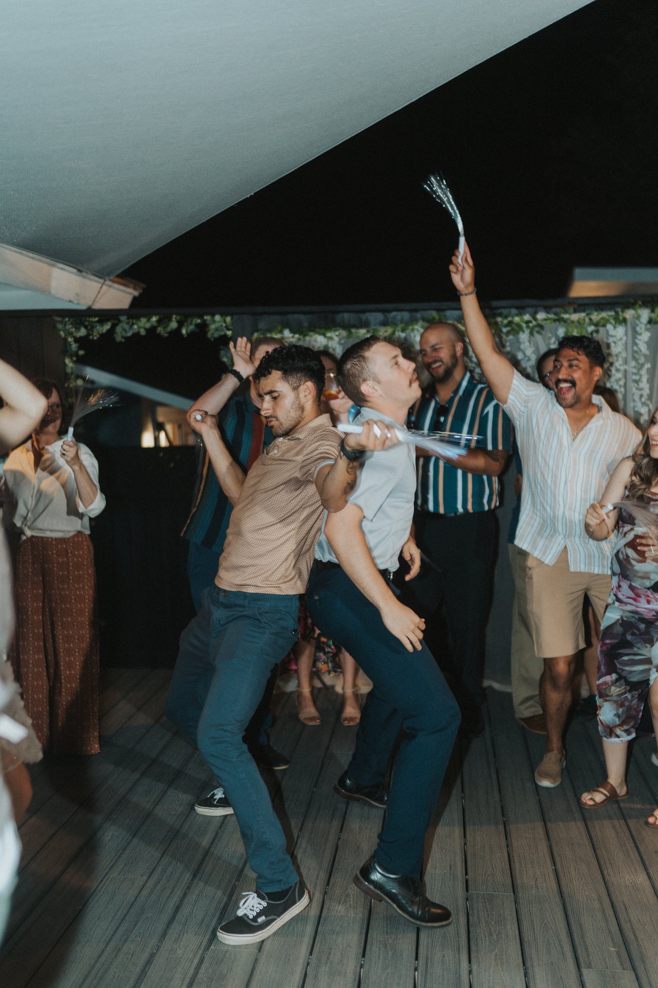 The groomsmen dancing under the shade sail