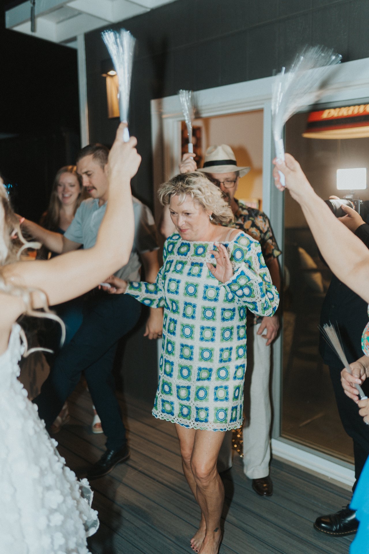 A guest in a patterned dress dancing with light up wands