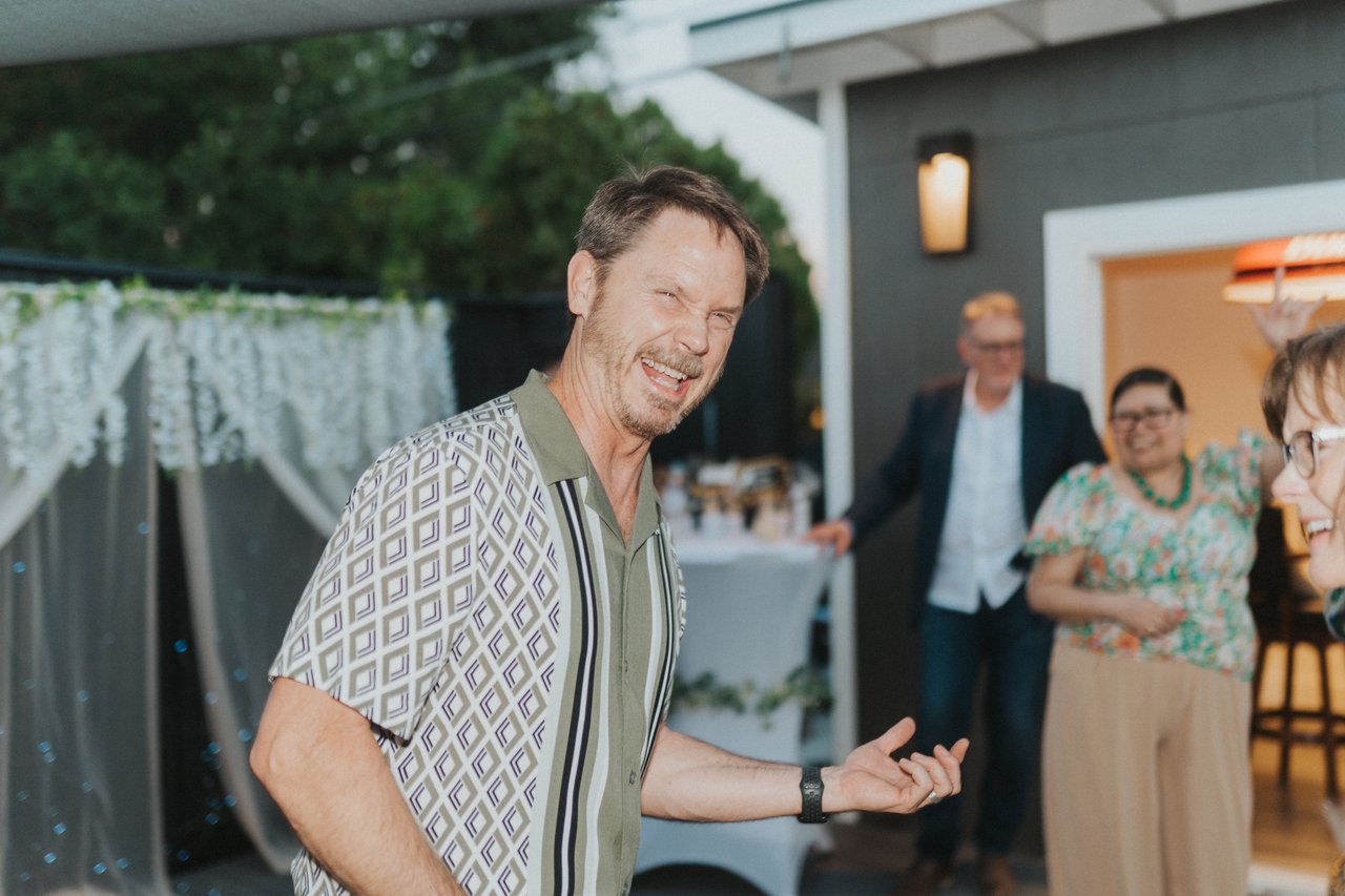 A wedding guest smiling in the backyard