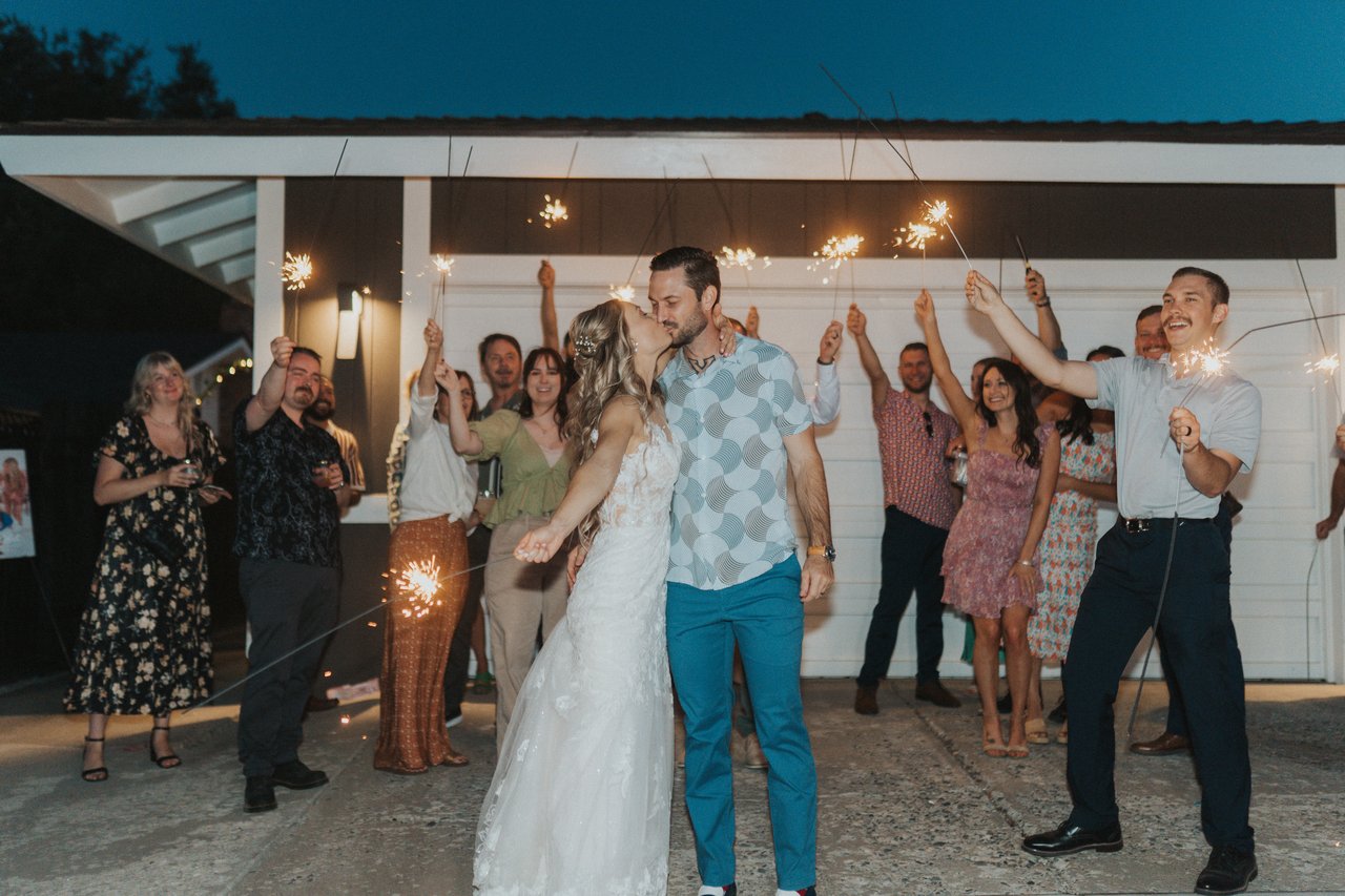 The whole crowd holding sparklers in the backyard