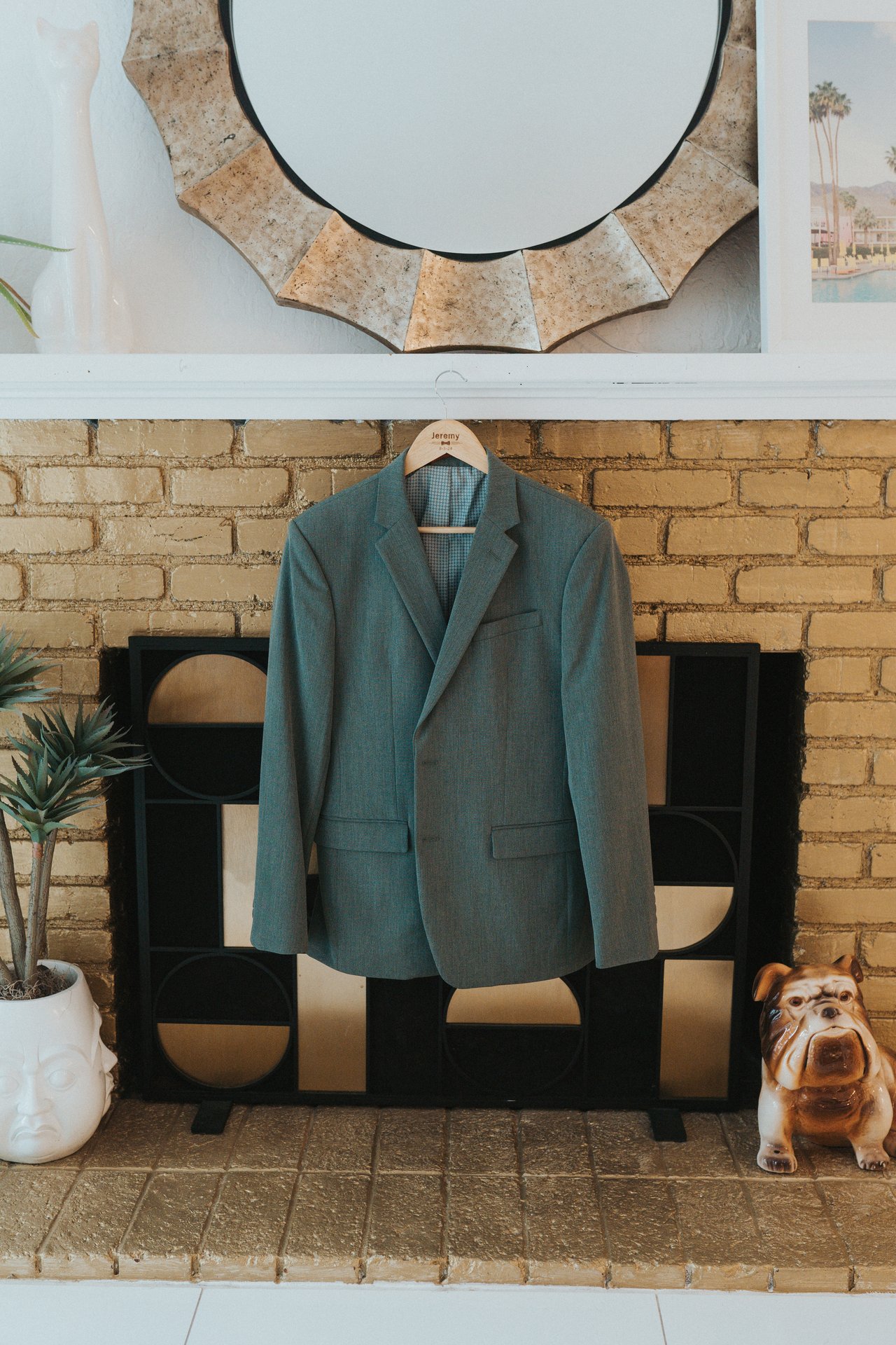Jeremy's sage green suit jacket hanging over the fireplace