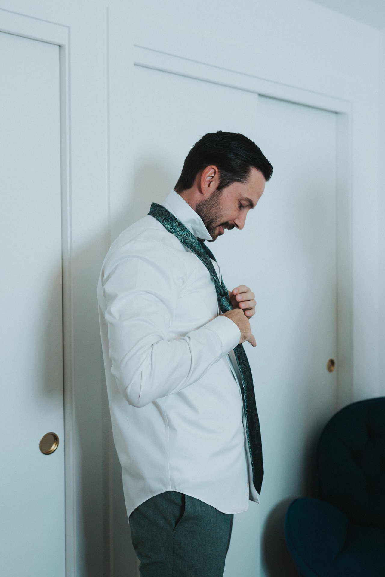 Jeremy tying his tie before the ceremony