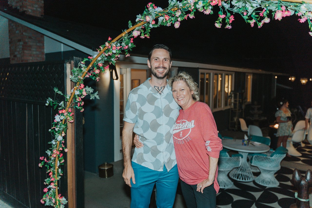 Jeremy with a guest under the floral arch