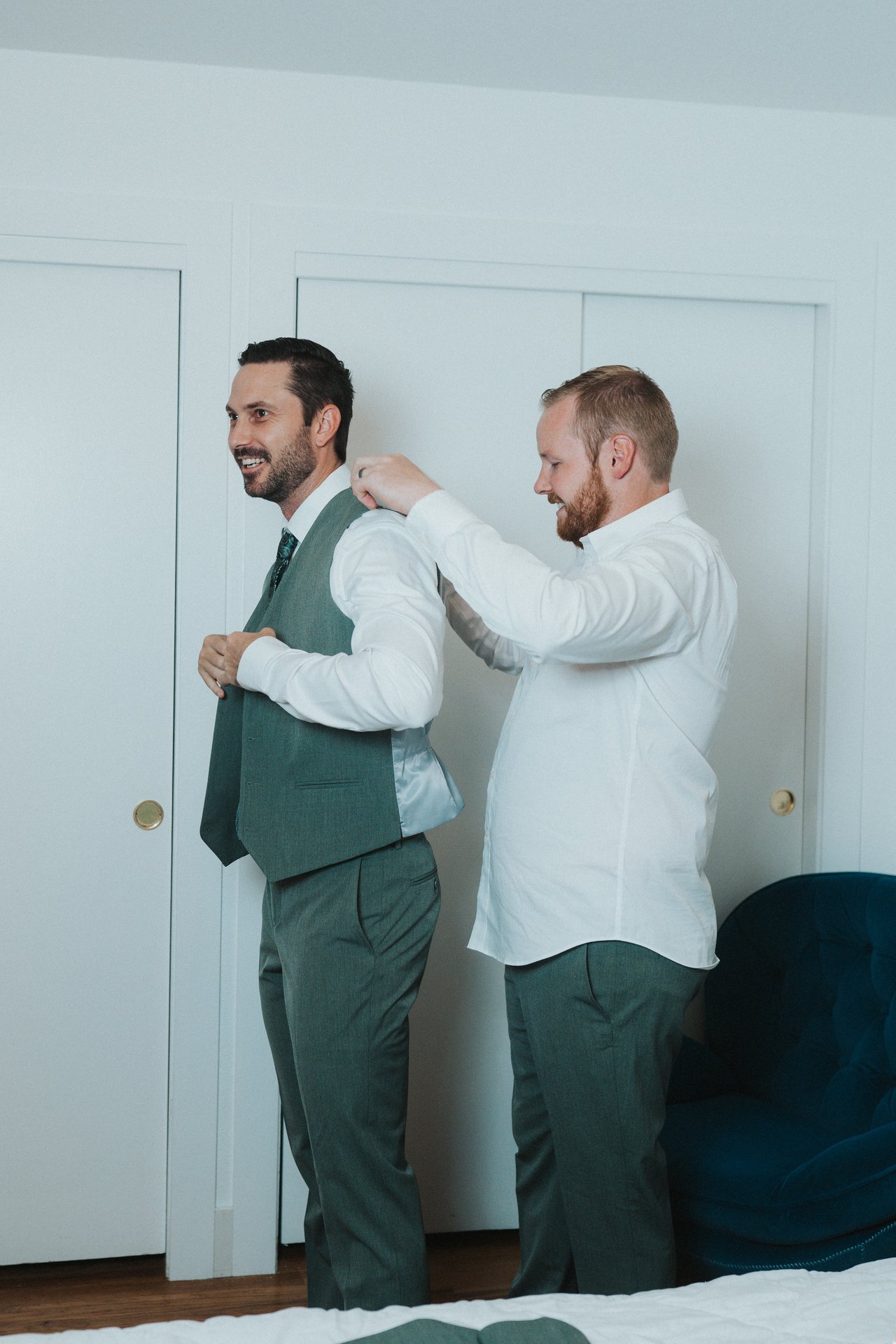 A groomsman helps Jeremy into his vest