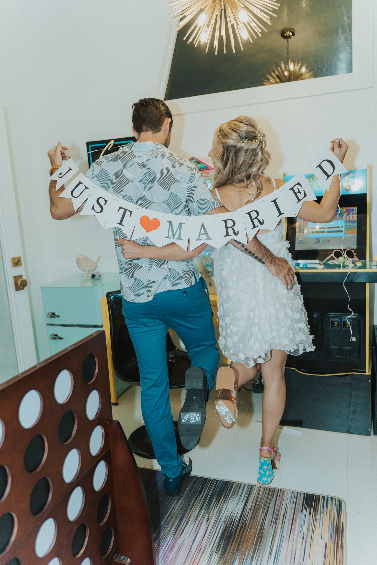 Lexy and Jeremy with the Just Married banner, seen from behind