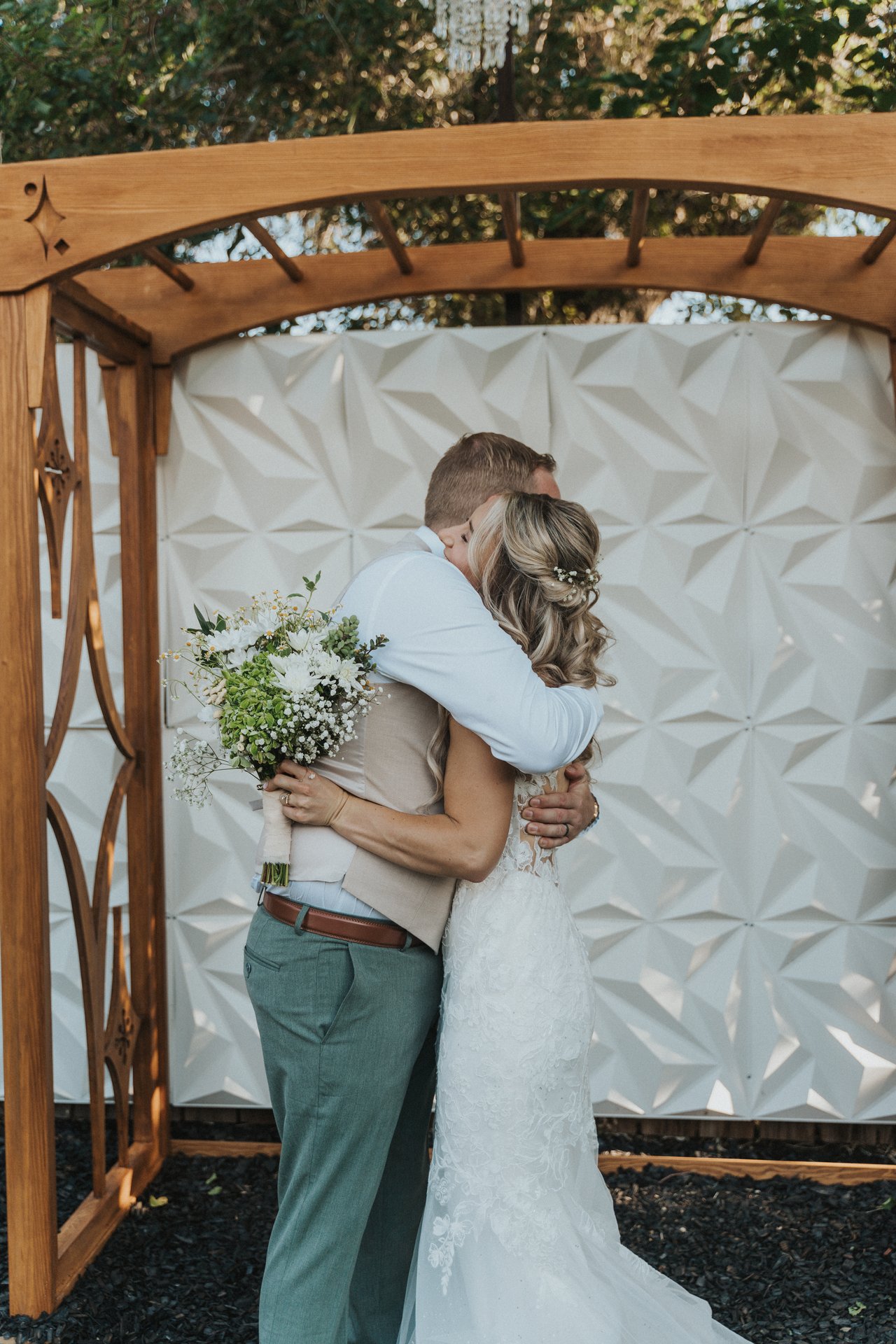Lexy hugs a groomsman at the arbor
