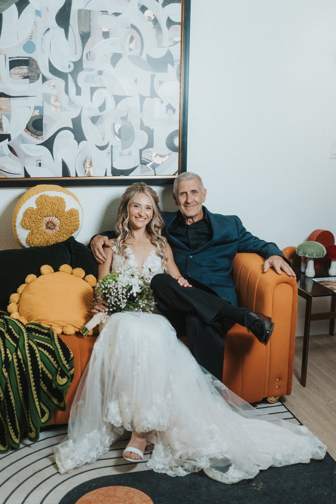 Lexy sits with her dad on the orange couch