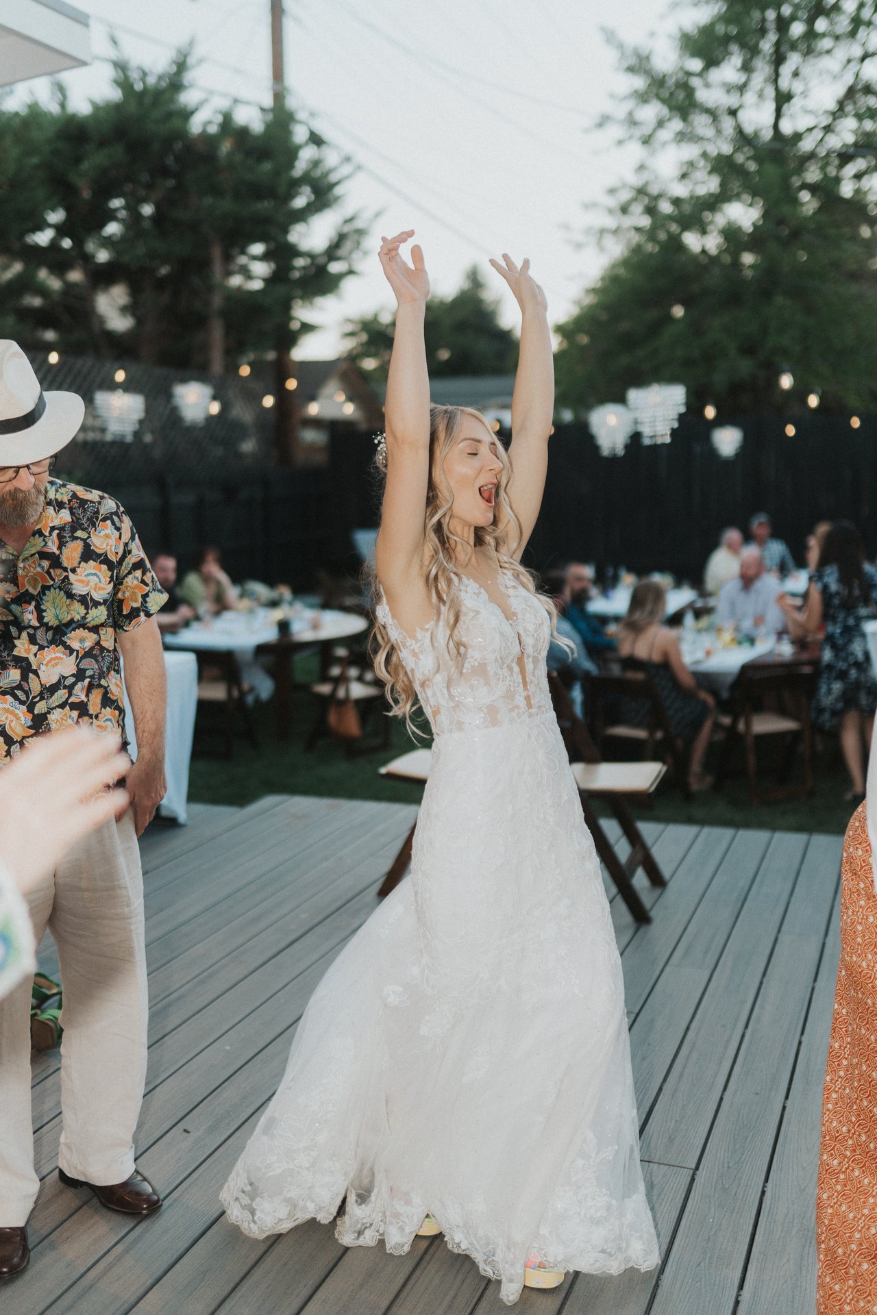 Lexy throws her arms up in her wedding dress