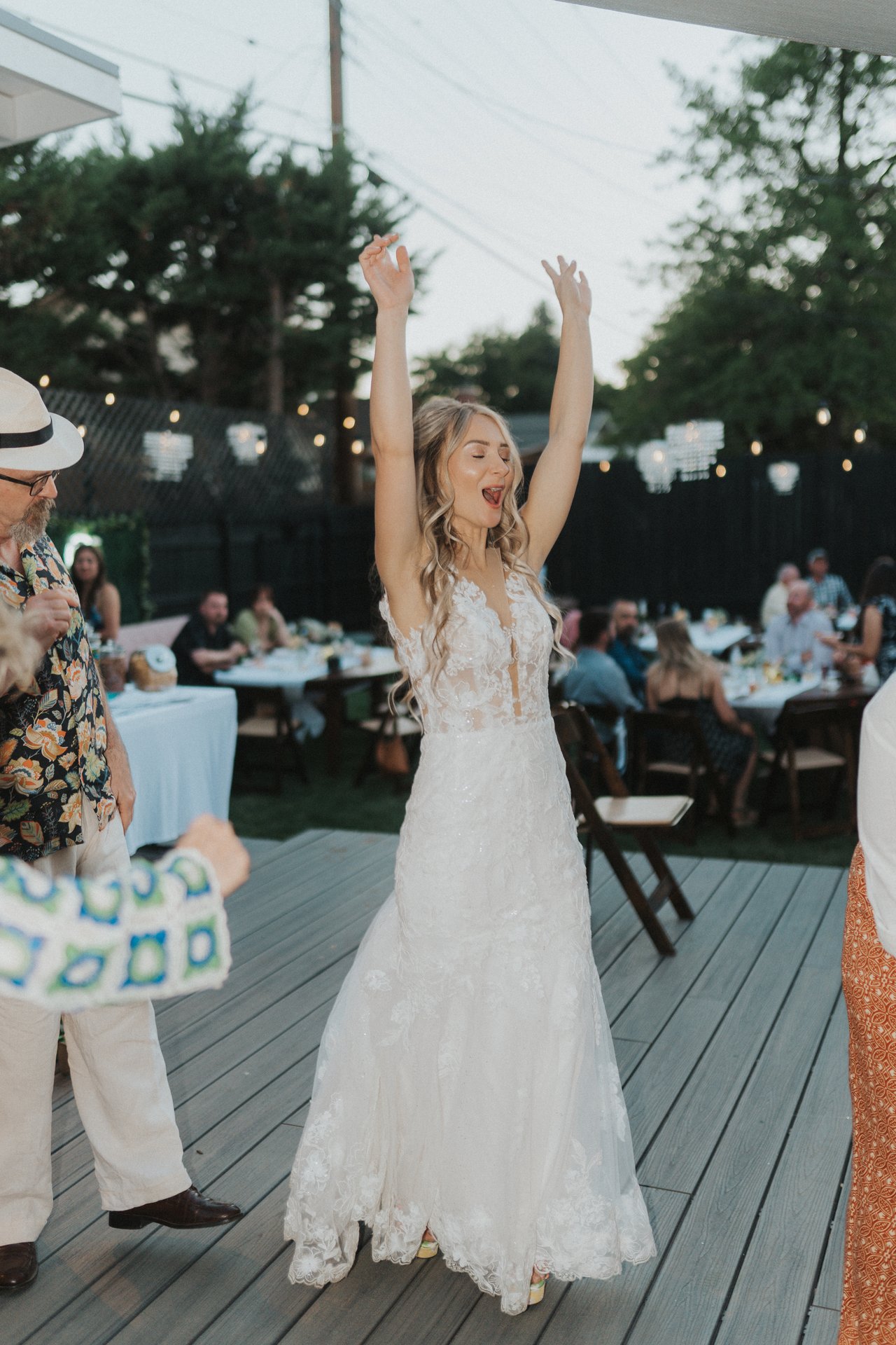 Lexy laughing with her arms raised in her wedding dress