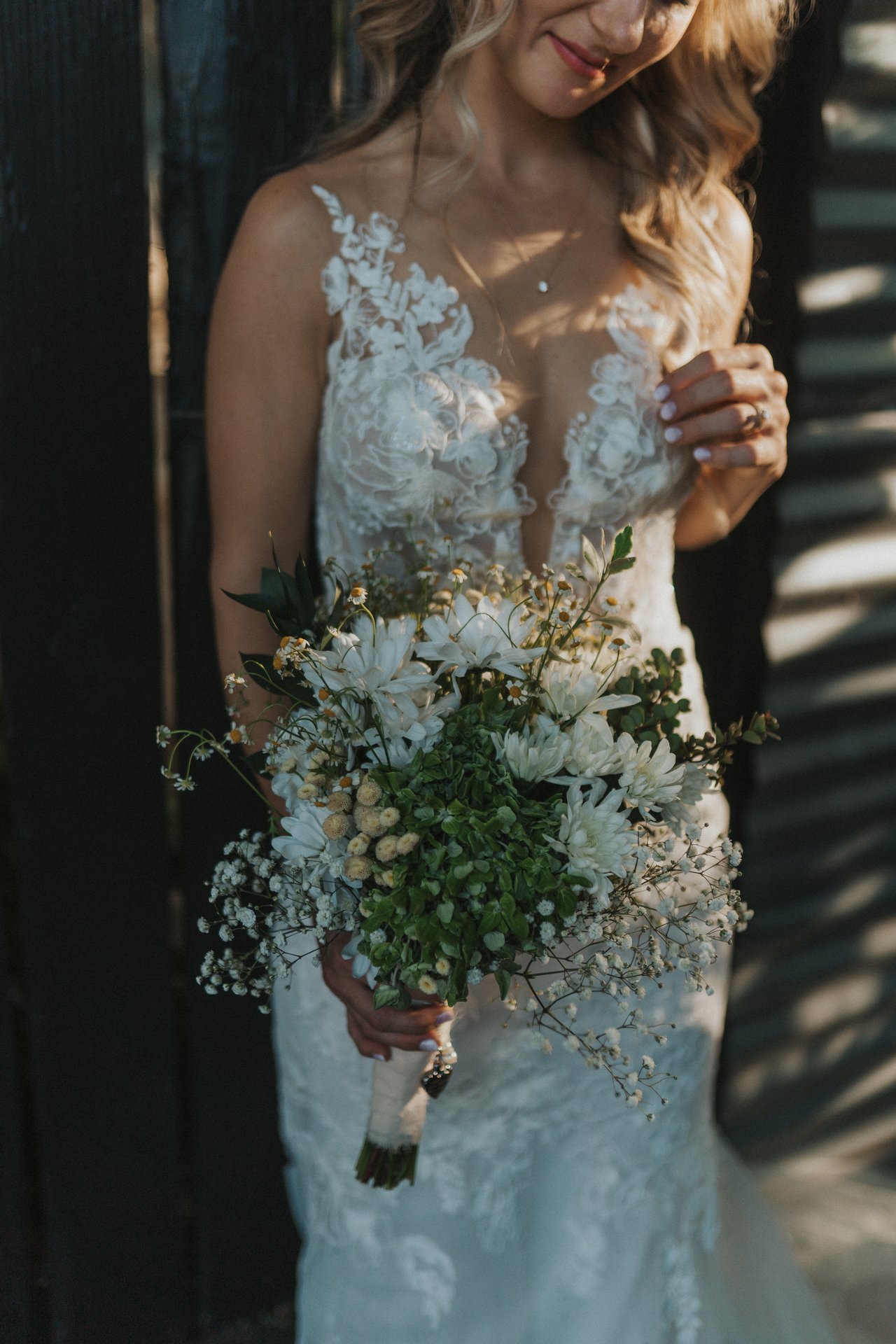 Lexy smiling down at her bouquet