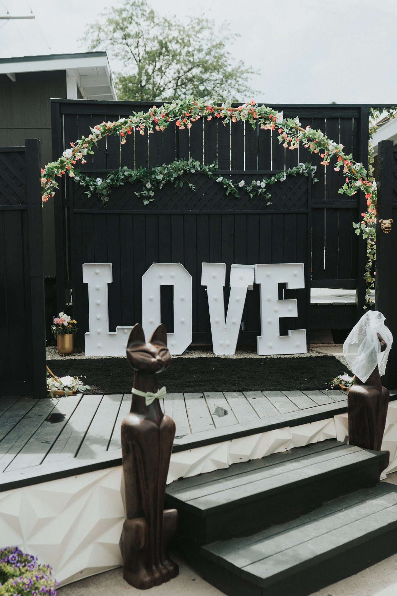 Light up LOVE letters on the deck under a floral arch